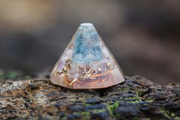 Orgonite with amazonite stone and metal components on natural background