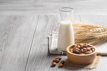 Almond milk with almond on a wooden table. 