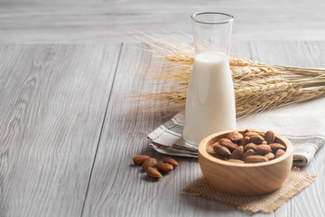 Almond milk with almond on a wooden table. 