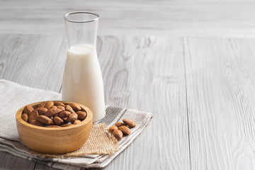 Almond milk with almond on a wooden table. 