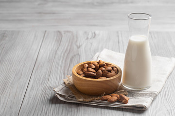 Almond milk with almond on a wooden table. 