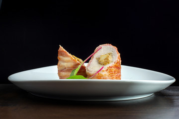 Chicken breast roll with filling. Decorated with herbs.