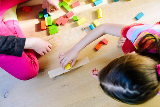 children playing with colorful wooden blocks - view from above