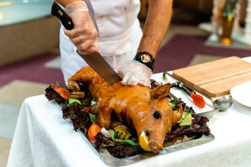 Roast pig. Roasted piglet with vegetables on platter