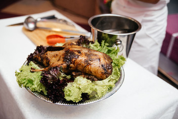 Baked duck on a platter with vegetables and salad