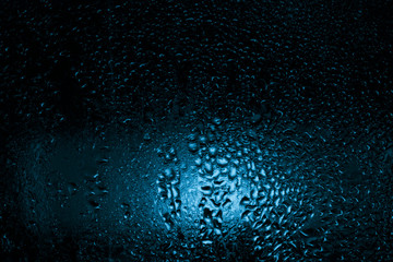 contrast drops on the glass, blue tint, dark fogged glass, texture, background 