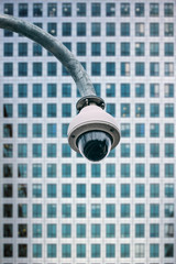 Fototapeta na wymiar Security camera with a glass building on the background
