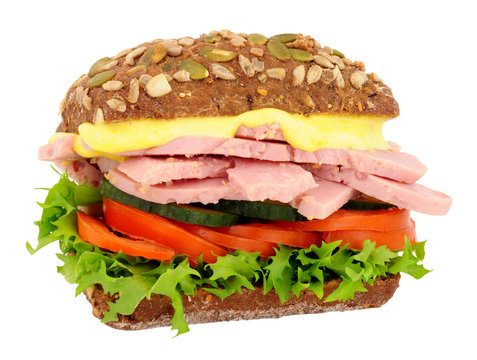 Ham salad sandwich in a pumpkin and sunflower seed dark rye bread roll isolated on a white background