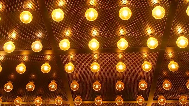 Many bright glowing glass lamps. Illumination of set Edison retro lamps on dark rabitz background. Fashionable loft design with Fashionable loft design with Edison bulbs. Abstract industrial