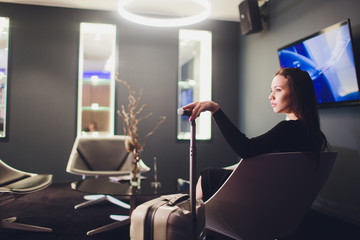 Businesswoman sitting at the airport lounge, waiting for the flight. Thoughtful woman sitting on...
