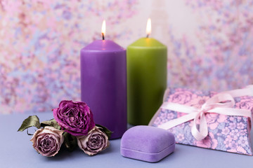 Obraz na płótnie Canvas The romantic Valentine background or wedding. Candles, flowers, a gift in purple tones. Selective focus. Copy space.