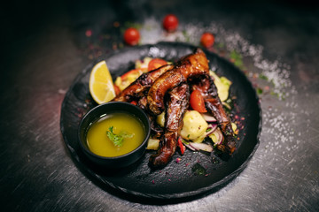 Close up of smoked carp on top of potato salad. On plate little bowl of soup.
