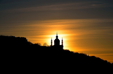 Silhouette of the church on a shout on a sunset background