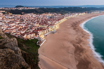 Nazar&eacute; beach, in Portugal, at dusk with lights on, seen from the S&Atilde;&shy;tio's viewpoint.