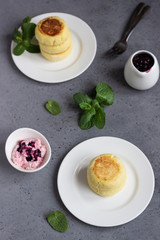 Cottage cheese pancakes or fritters with blueberry sauce and mint. Traditional Ukrainian and Russian cuisine. Syrniki. Healthy and diet breakfast.