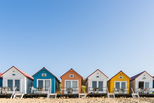 Multi colored  beach houses in a row under a blue sky on a sunny day 