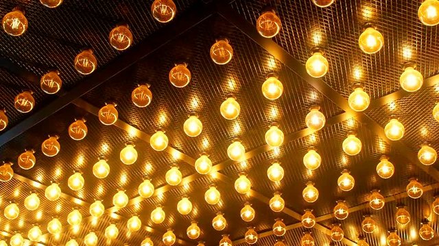 Many bright glowing glass lamps. Illumination of set Edison retro lamps on dark rabitz background. Fashionable loft design with Fashionable loft design with Edison bulbs. Abstract industrial