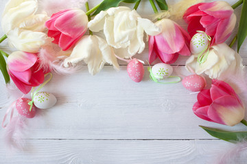 Easter wooden background with flowers tulips and colored eggs