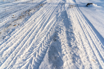 Closeup Details of Tire Marks in Snow on Sunny Winter Day