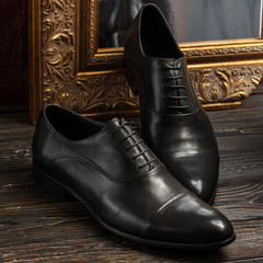 Black oxford men shoes on dark wooden background