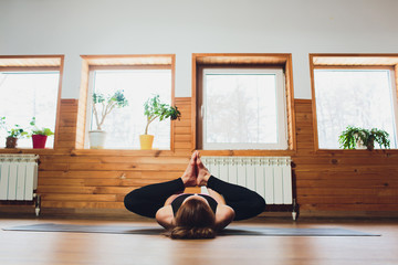 yoga, doing Ardha Padmasana exercise, Half Lotus pose with mudra gesture, working out, wearing...
