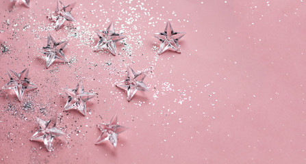 Silver glass stars glitter on pink background.