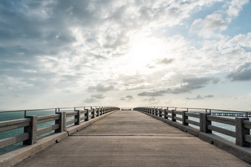Old Bahia Honda Bridge Trail in state park during day in Florida Keys, with hiking path, nobody, sun behind clouds in sky, freedom concept