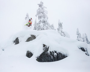 Extreme Snowboarder Jumping Off Powder Cliff Holding Grab in Backcountry