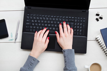 Female hands working on laptop. Office desktop on white background.