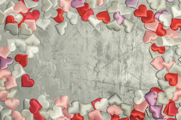 On a gray background many multicolored hearts are laid out in a circle. In the center is a copy space.