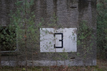 Painted Number 3 Three on concrete wall on an abandoned summer camp house