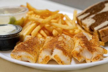 Bar food:  Baked fish plate with french fries, marbled rye bread, french fries, coleslaw, lemon wedges, and tartar sauce.