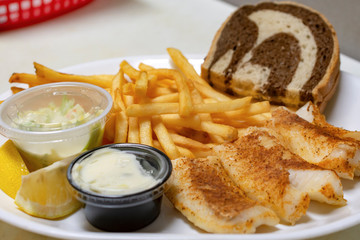 Bar food:  Baked fish plate with french fries, marbled rye bread, french fries, coleslaw, lemon wedges, and tartar sauce.
