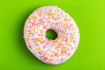 Delicious vanilla donut with sprinkle on bright green background