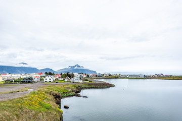Fototapeta na wymiar Landscape cityscape view of peaceful picturesque village by tranquil fjord water river and mountains in small fishing town called Hofn in Iceland cityscape