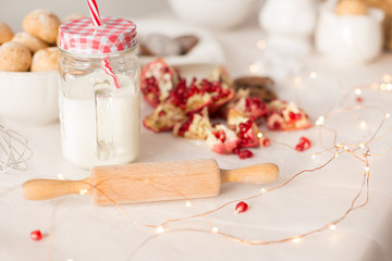 red garnet. new year mood. glass of milk. rolling pin for test. Christmas gingerbread. cookie