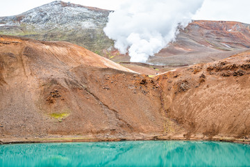 Viti Crater in Krafla caldera geothermal blue green turquoise color colorful lake water and industrial smoke steam vapor landscape from power plant