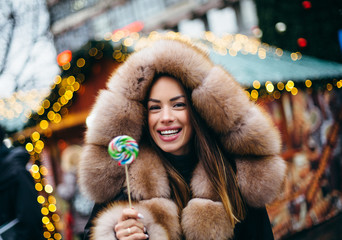 Girl with lollipop posing on street