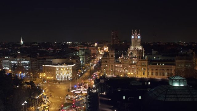 Night timelapse shot of Madrid, Spain. Cityscape with illuminated Cybele Palace and Cibeles Square busy with traffic
