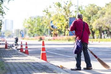 Man cleaning garbage on the road