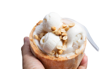Fototapeta na wymiar Coconut ice cream in coconut shell and roasted peanuts in hand isolated.