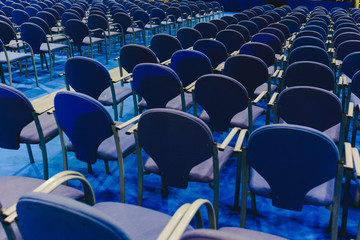 Many empty blue row chairs in a theater.
