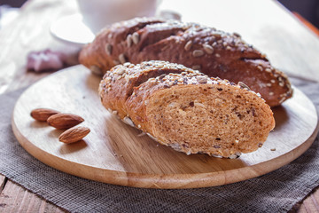 Rye bread with sunflower seeds, sesame and flax on wooden board.