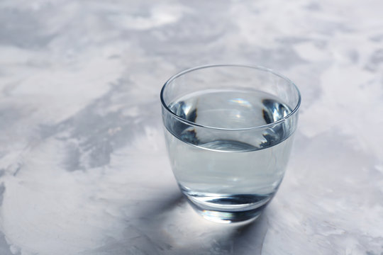 Glass with fresh water on table. Space for text