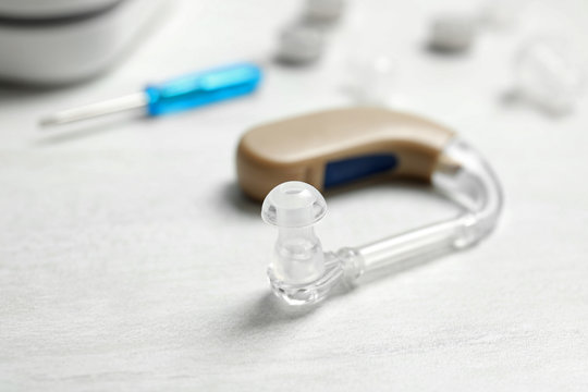 Hearing aid on white table, closeup. Medical device