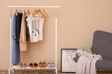 Wardrobe rack with female clothes in stylish dressing room