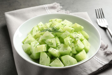 Delicious cucumber salad with dill in bowl served on grey table