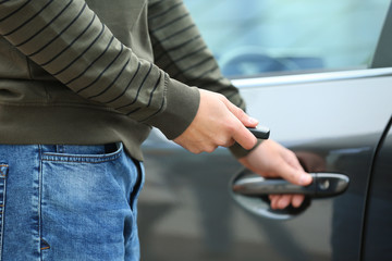 Closeup view of man opening car door with remote key