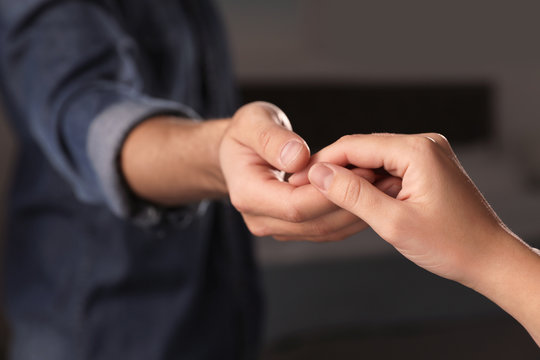 Man giving helping hand to woman indoors, closeup