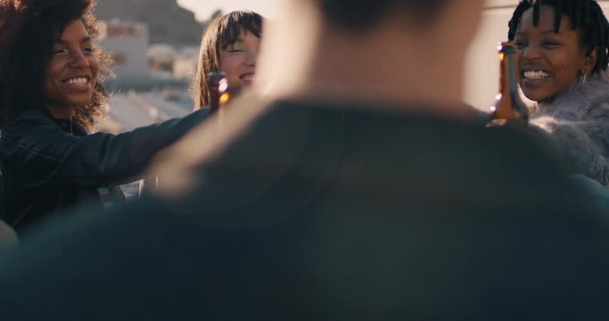 slow motion group of multi ethnic friends celebrating rooftop party making toast drinking alcohol enjoying reunion celebration on weekend social gathering at sunset